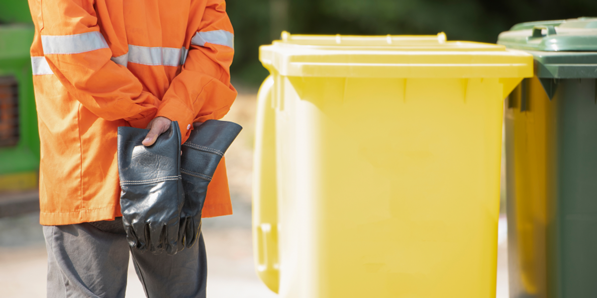Müllmann neben gelber Tonne